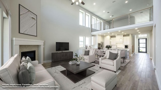 121 La Venta Loop, Liberty Hill, TX 78642 - living area with a high ceiling, ceiling fan, light wood finished floors, recessed lighting, and a glass covered fireplace