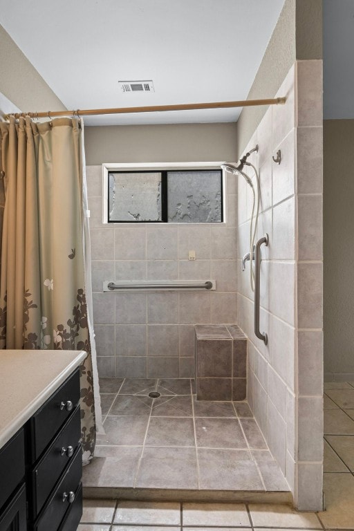 bathroom with tile patterned flooring, curtained shower, and vanity