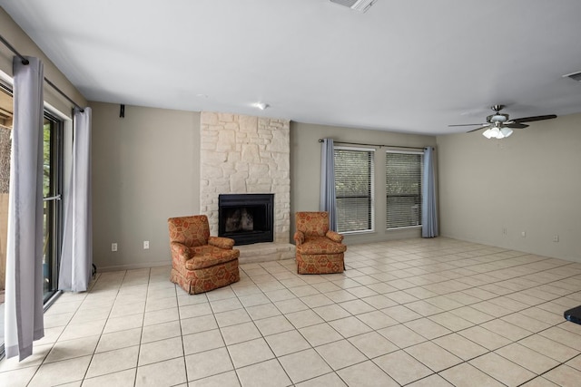 unfurnished living room featuring light tile patterned floors, ceiling fan, and a fireplace