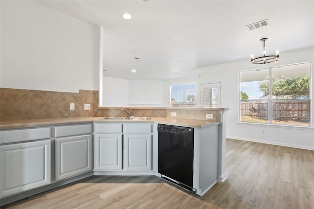 kitchen with light hardwood / wood-style floors, sink, backsplash, pendant lighting, and black dishwasher