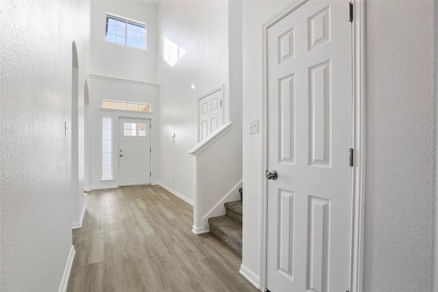 entrance foyer featuring light hardwood / wood-style floors and a towering ceiling