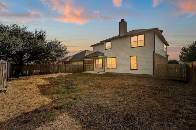 back house at dusk featuring a yard