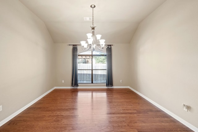 unfurnished room featuring hardwood / wood-style floors, an inviting chandelier, and lofted ceiling