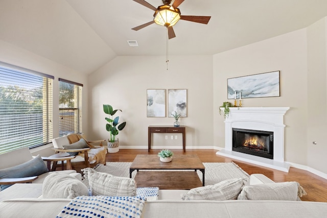 living room featuring hardwood / wood-style flooring, ceiling fan, and vaulted ceiling