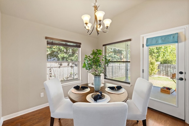 dining space with vaulted ceiling, a notable chandelier, and dark hardwood / wood-style floors