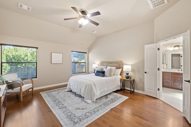 bedroom with ceiling fan, wood-type flooring, connected bathroom, and lofted ceiling