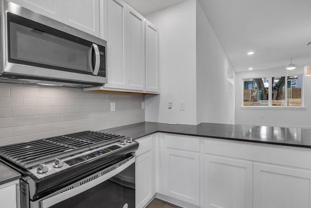 kitchen featuring white cabinetry, kitchen peninsula, stainless steel appliances, and tasteful backsplash