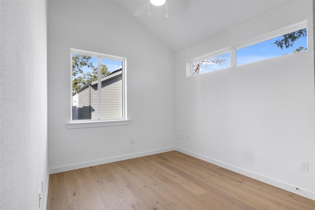 empty room with ceiling fan, a wealth of natural light, lofted ceiling, and light hardwood / wood-style floors