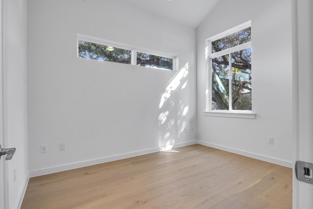 unfurnished room with light wood-type flooring and lofted ceiling