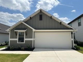 222 Spirit St, Elgin, TX 78621 - craftsman house with board and batten siding, concrete driveway, a garage, and a front lawn
