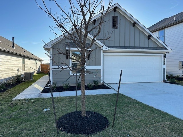 222 Spirit St, Elgin, TX 78621 - view of front of home featuring board and batten siding, a front lawn, and concrete driveway
