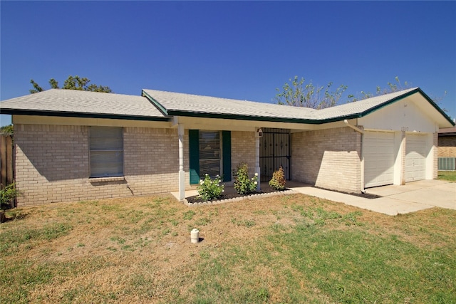 ranch-style house featuring a front lawn, a garage, and central AC