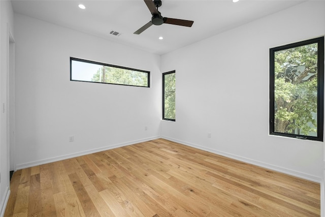 empty room with ceiling fan, light hardwood / wood-style floors, and plenty of natural light