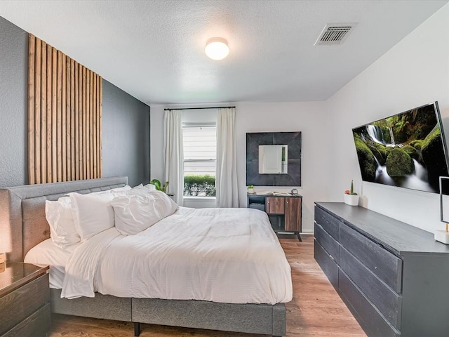 bedroom with a textured ceiling and hardwood / wood-style flooring