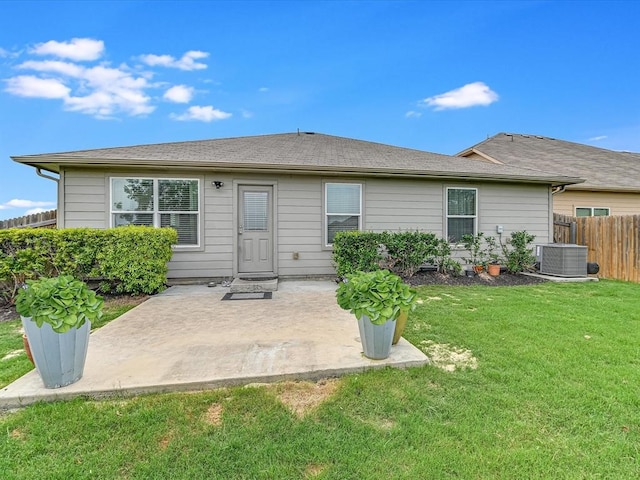 rear view of property with cooling unit, a lawn, and a patio area