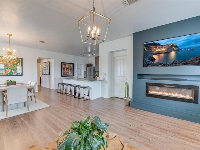 living room featuring light hardwood / wood-style flooring and an inviting chandelier