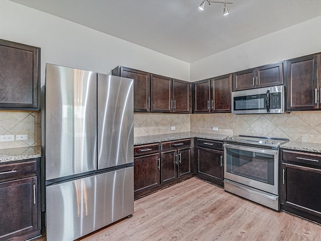 kitchen featuring decorative backsplash, light wood-type flooring, and appliances with stainless steel finishes