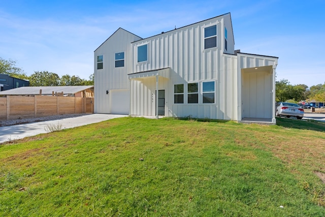 rear view of property featuring a garage and a lawn