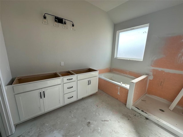 bathroom featuring concrete flooring and a tub to relax in