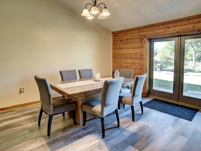 325 Simpson Ave, Cedar Creek, TX 78612 - dining space featuring lofted ceiling, a chandelier, light wood-style flooring, baseboards, and french doors