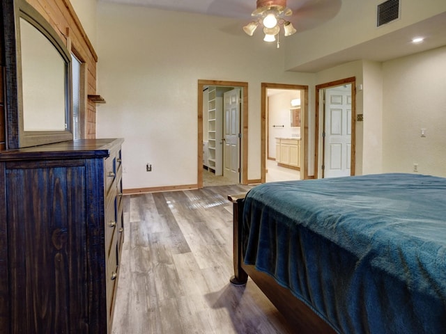 325 Simpson Ave, Cedar Creek, TX 78612 - bedroom featuring baseboards, light wood finished floors, ensuite bathroom, a spacious closet, and ceiling fan