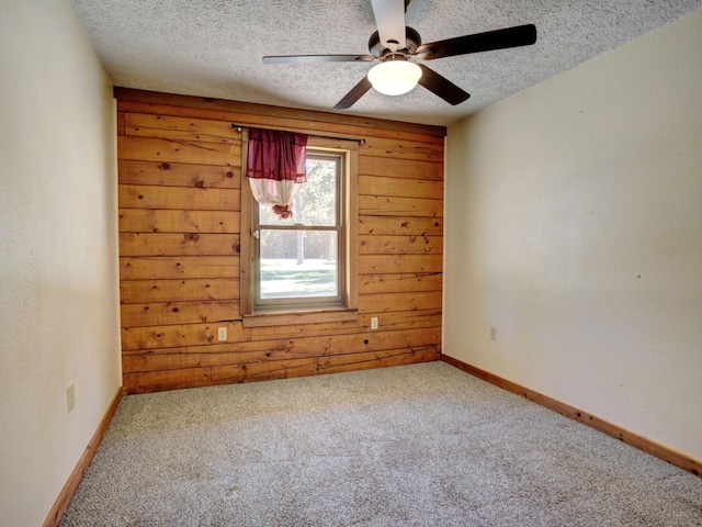 325 Simpson Ave, Cedar Creek, TX 78612 - empty room with ceiling fan, carpet floors, a textured ceiling, wooden walls, and baseboards