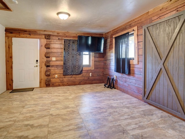 foyer with wood walls and a barn door