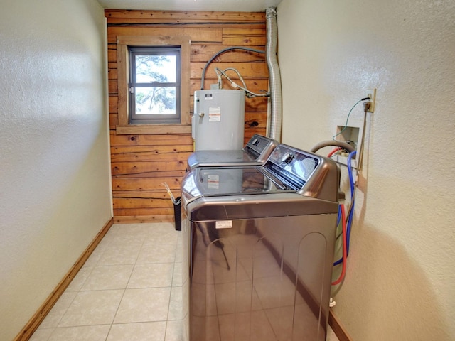 washroom with wood walls, light tile patterned floors, gas water heater, and independent washer and dryer