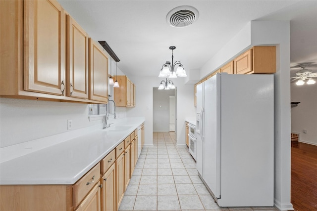 kitchen with sink, light brown cabinets, decorative light fixtures, white refrigerator with ice dispenser, and light wood-type flooring