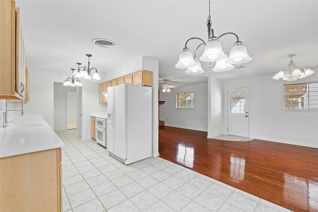 kitchen with ceiling fan with notable chandelier, sink, light hardwood / wood-style flooring, light brown cabinetry, and white appliances