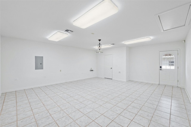 empty room featuring electric panel and light tile patterned floors