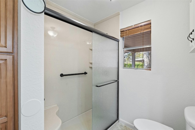 bathroom featuring a shower with door and toilet