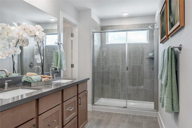 bathroom featuring a shower with door, vanity, and tile patterned flooring