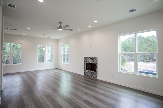 unfurnished living room with dark hardwood / wood-style flooring and ceiling fan