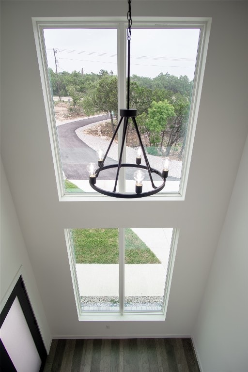 details with wood-type flooring and an inviting chandelier