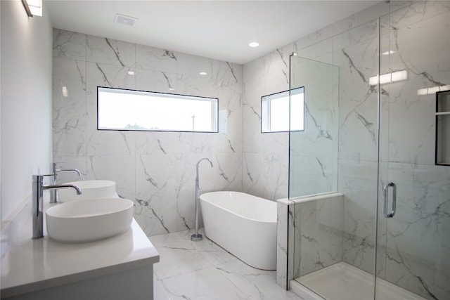 bathroom with vanity, separate shower and tub, and tile walls