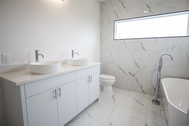 bathroom with toilet, a tub to relax in, vanity, and tile walls