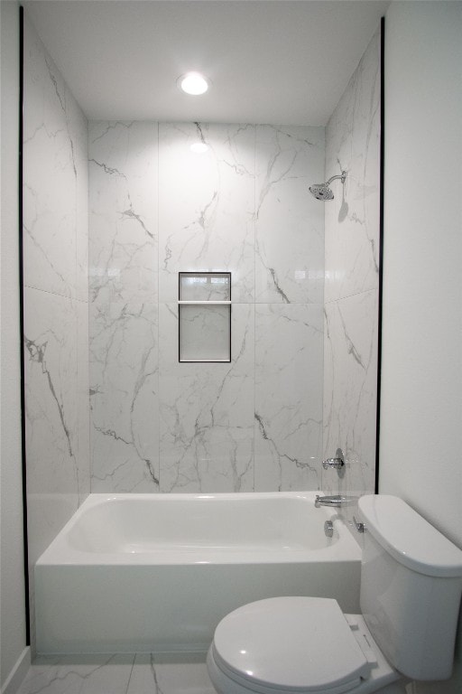 bathroom featuring tiled shower / bath and toilet