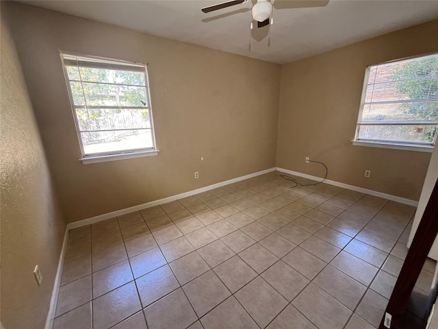 spare room featuring plenty of natural light, light tile patterned floors, and ceiling fan