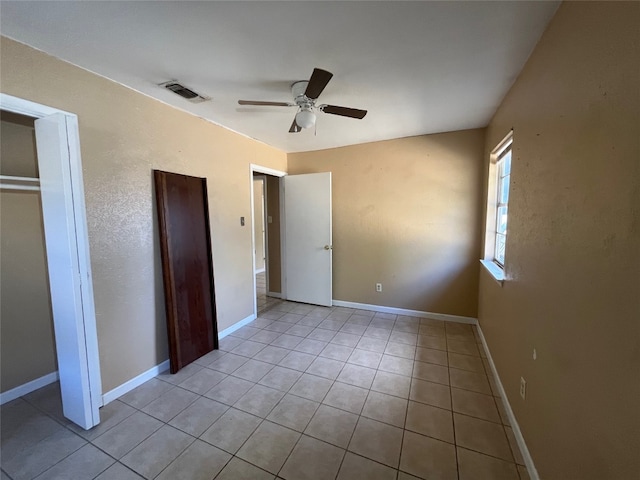 unfurnished bedroom featuring light tile patterned flooring, ceiling fan, and a closet