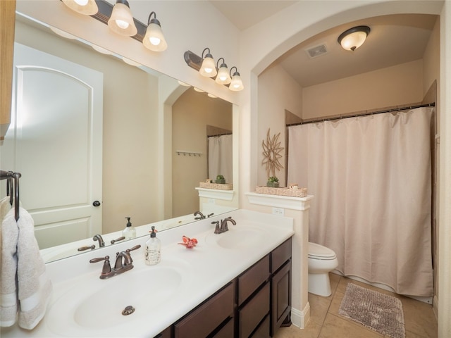 bathroom with toilet, vanity, and tile patterned floors