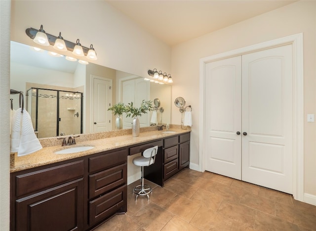 bathroom with tile patterned flooring, vanity, and a shower with door