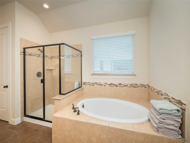 bathroom featuring shower with separate bathtub, lofted ceiling, and tile patterned floors