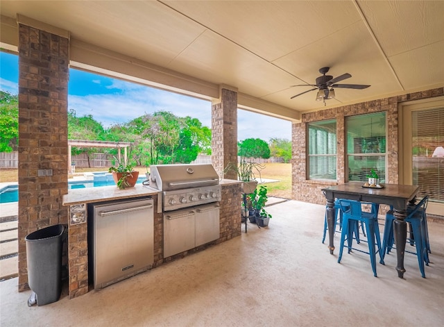 view of patio / terrace featuring ceiling fan, exterior kitchen, and a grill