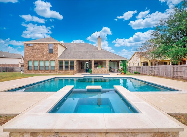 view of swimming pool featuring an in ground hot tub and a patio area