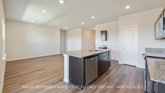 kitchen with hardwood / wood-style floors, stainless steel appliances, sink, and an island with sink