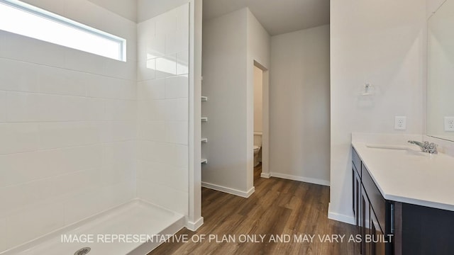 bathroom featuring walk in shower, wood-type flooring, toilet, and vanity