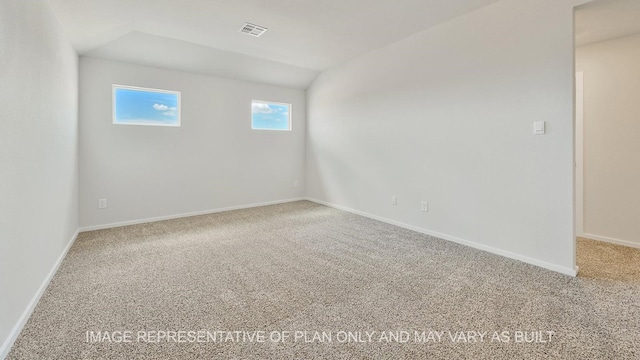 carpeted empty room featuring lofted ceiling