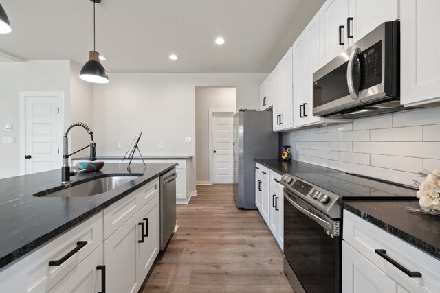 kitchen featuring white cabinetry, appliances with stainless steel finishes, sink, and light hardwood / wood-style floors