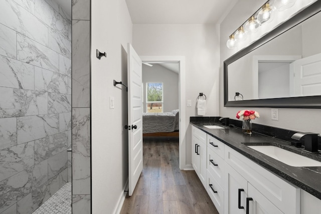 bathroom with tiled shower, vanity, and hardwood / wood-style flooring